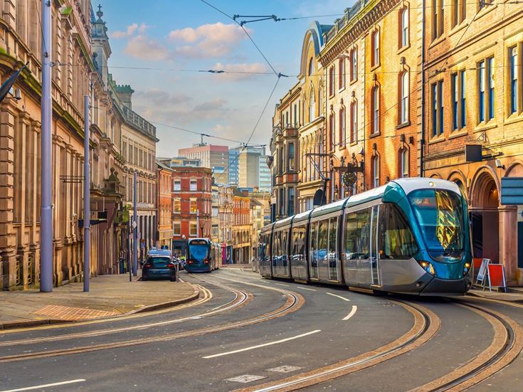 Trams moving through a city street in Nottingham.