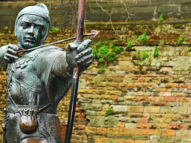 A statue of Robin Hood aiming his bow and arrow in Nottinghamshire.
