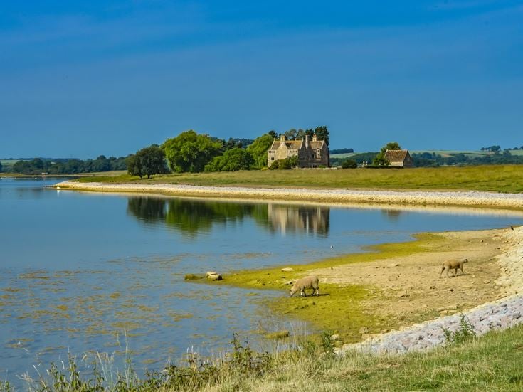 a body of water with a building in the background