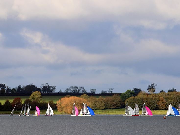 Boats with multicoloured sails on a lake in Rutland.
