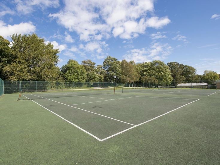 a tennis court with trees