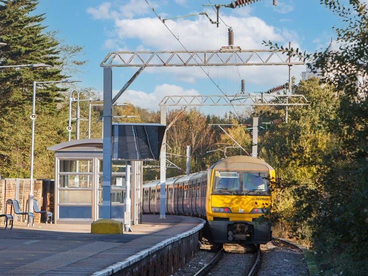 A yellow train on the platform at Colchester train station.