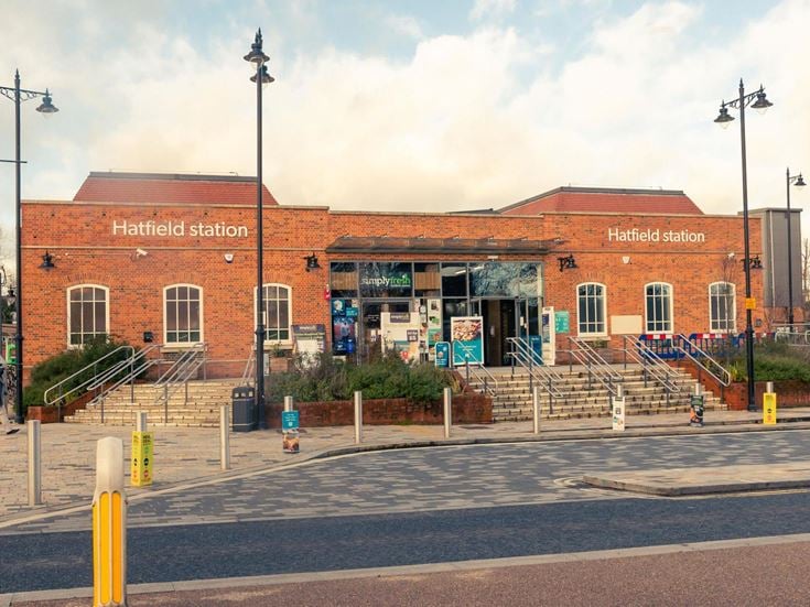 a brick building with stairs and a sidewalk