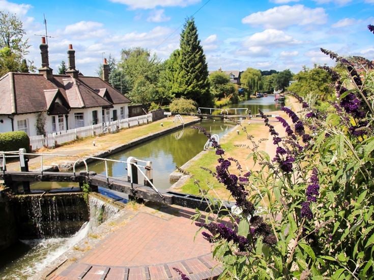 A pathway along the Grand Union Canal with a small bridge in the village of Berkhamsted in Hertfordshire.