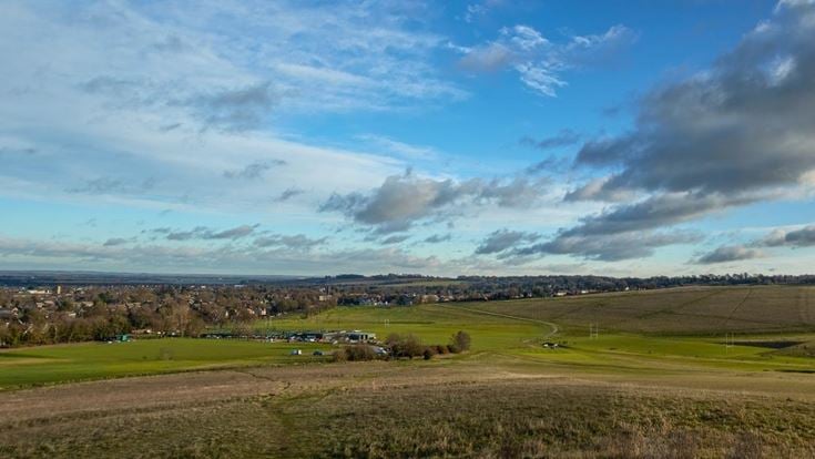 a large open field with a few buildings in it