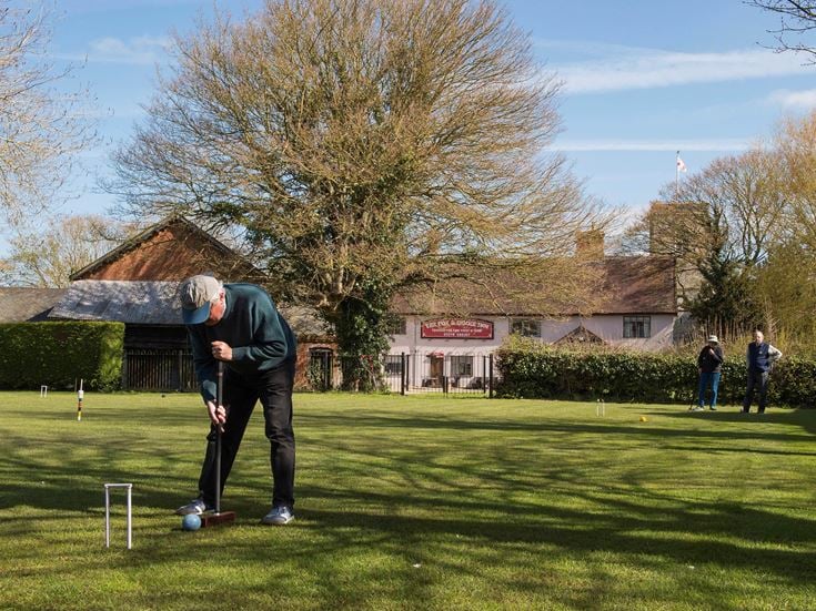 A retiree playing croquet at Fressington near Harleton, Norfolk
