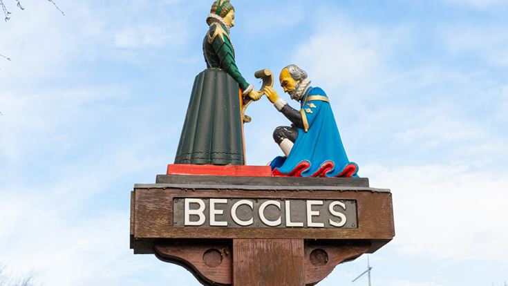 a statue of a man and woman holding hands on a pole