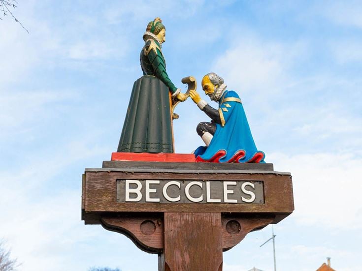 a statue of a man and woman holding hands on a pole