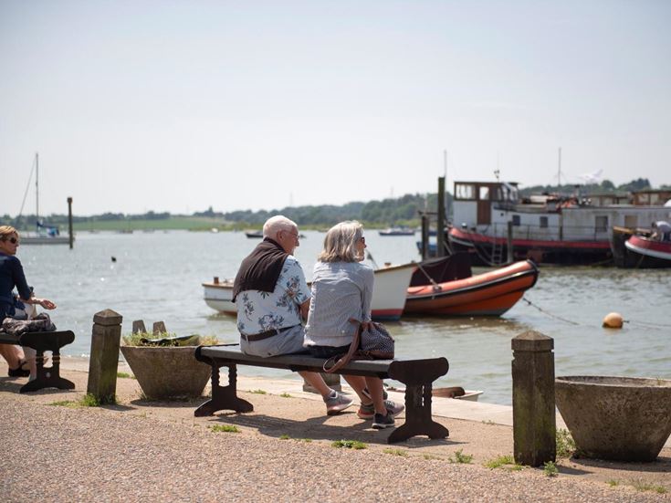 Two retirees sitting on a bench and enjoying the waterside near Martlesham Heath.