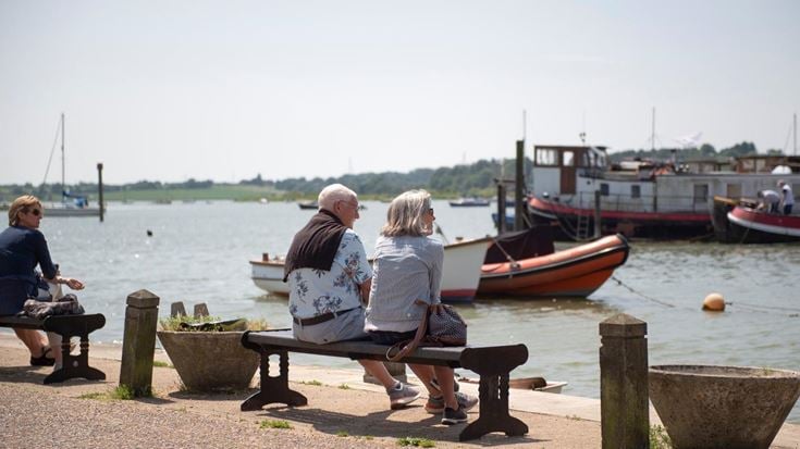 Two retirees sitting on a bench and enjoying the waterside near Martlesham Heath.