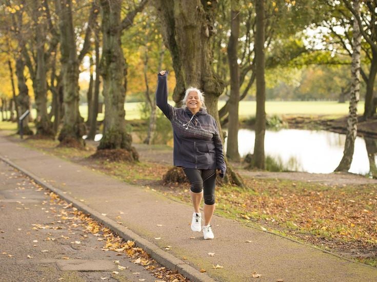 A retired lady waves to a friend while on a waterside jog in Oakwood.