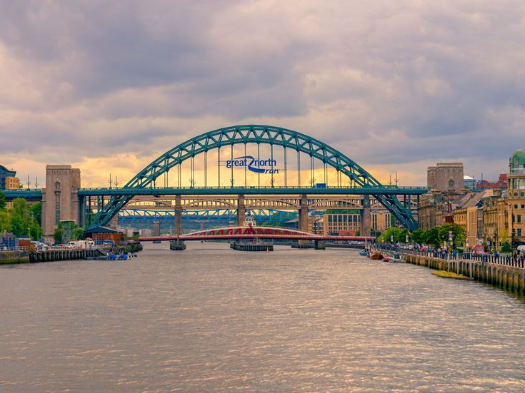 Three bridges crossing the River Tyne in Newcastle city, with a sign for the Great North Run.