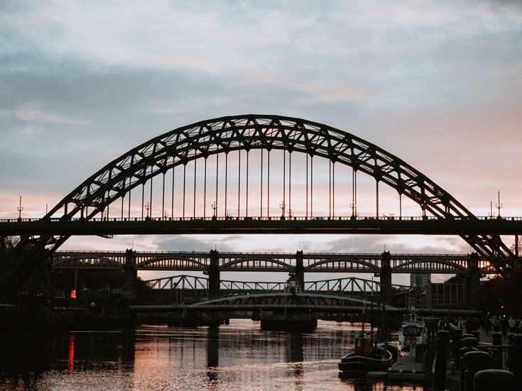 The silhouette of a bridge at dusk over the river in Tyne and Wear.