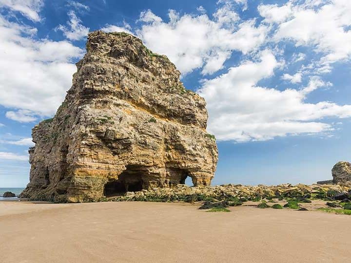 a large rock structure on a beach