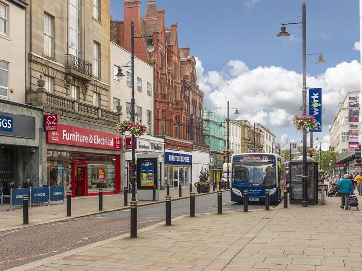 A street in Sunderland with shops and a bus.