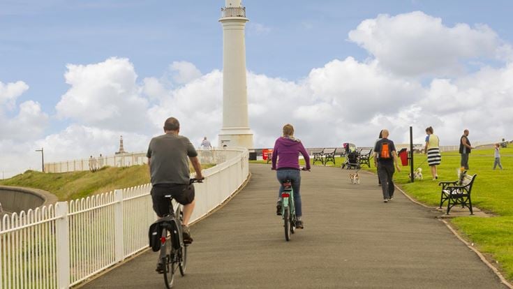 A group of walkers and cyclists on a popular trail towards Meik's Lighthouse in Sunderland.