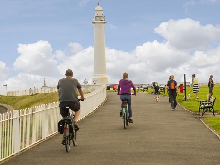A group of walkers and cyclists on a popular trail towards Meik's Lighthouse in Sunderland.