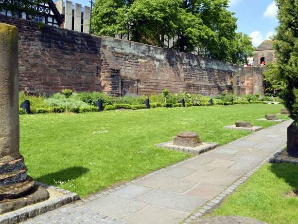 Maintained grass, brick walls, and stone remains at the Roman Gardens in Chester.
