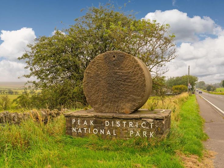 A stone sign welcoming drivers to the Peak District National Park.