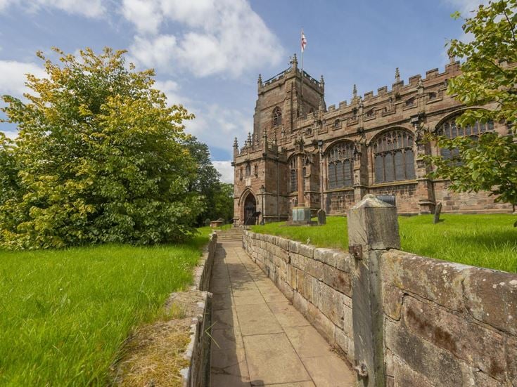 a stone wall leading to a castle