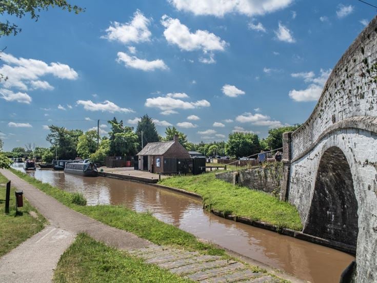 An arched bridge over the Shropshire Union Canal with boats moored at the Nantwich Canal Basin.
