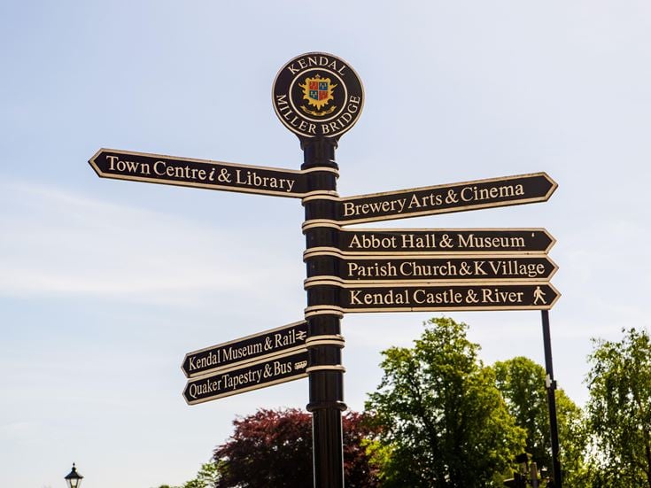 Town signpost showing directions to various places Kendal.