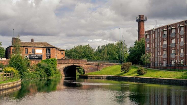 a river with a bridge and buildings in the background