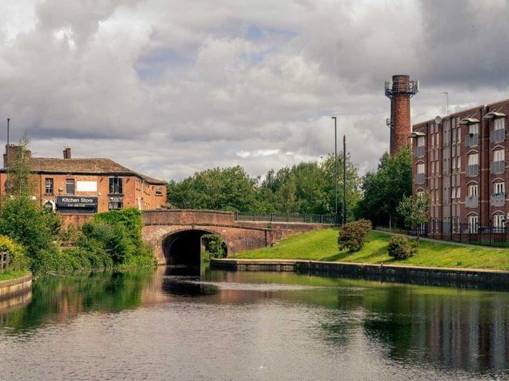 a river with a bridge and buildings in the background