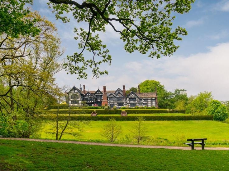 a large house with a lawn and trees in front of it