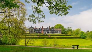 a large house with a lawn and trees in front of it