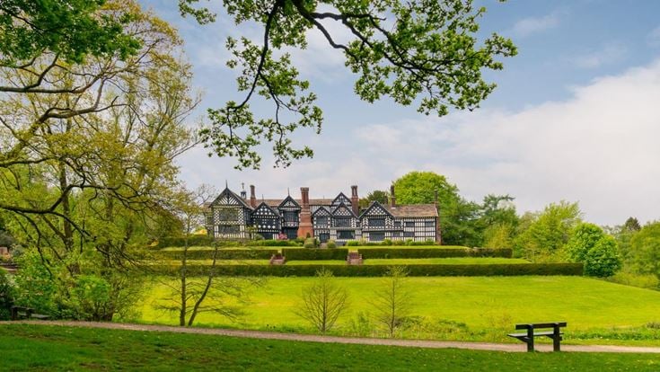 a large house with a lawn and trees in front of it