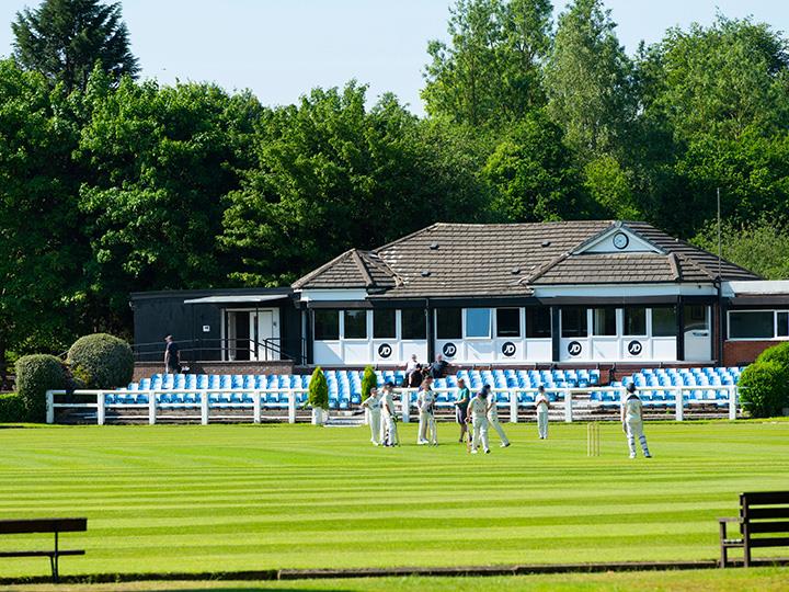 A cricket club in Rochdale, with a team on the green.