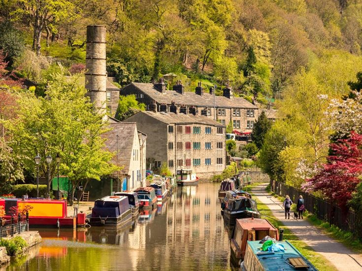 The Rochdale Canal lined with boats in Hebden Bridge.