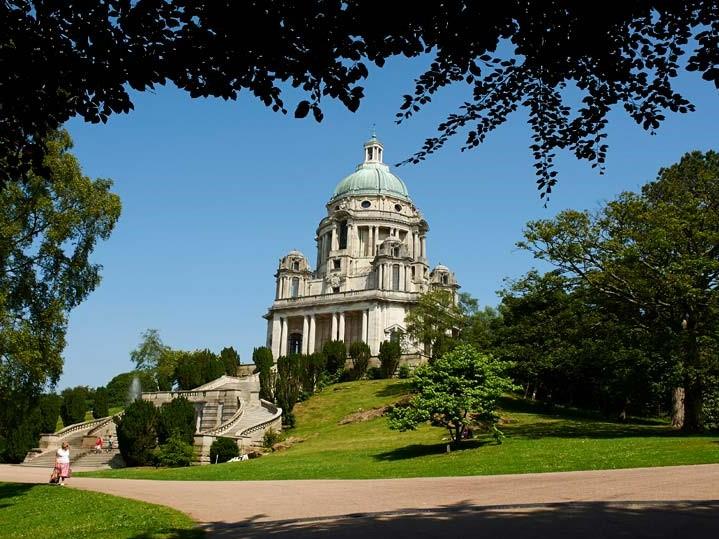 A view of Ashton Memorial in Williamson Park, Lancaster, from a flat pathway.