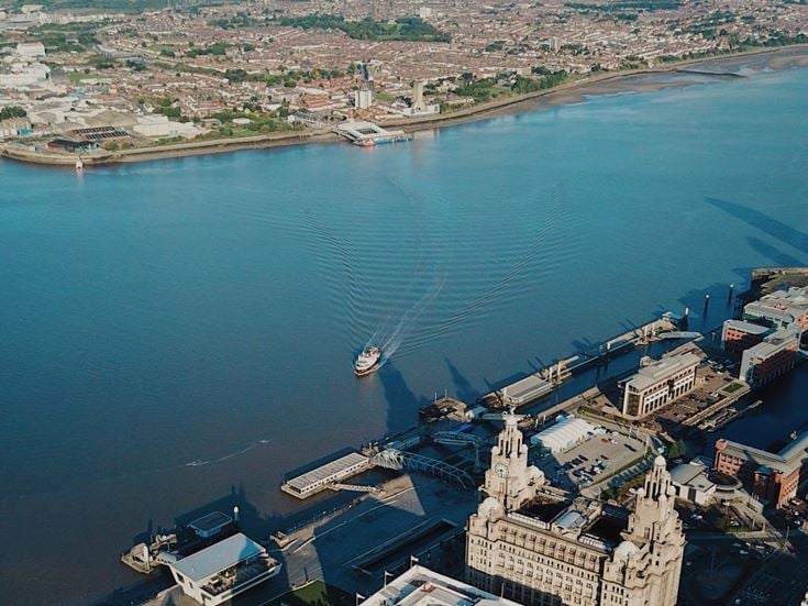 A ferry travels across the River Mersey, approaching a dock in Liverpool.