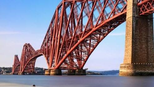 a large red bridge with Forth Bridge in the background