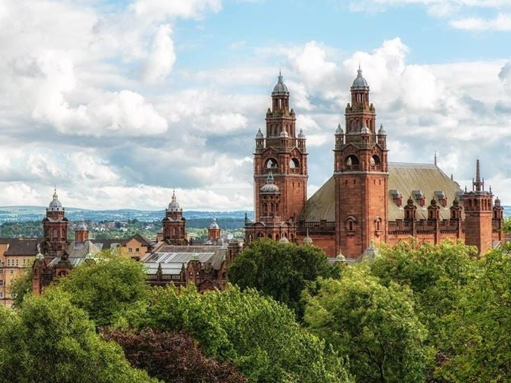 a large building with towers and trees in front of it with Mainz Cathedral in the background