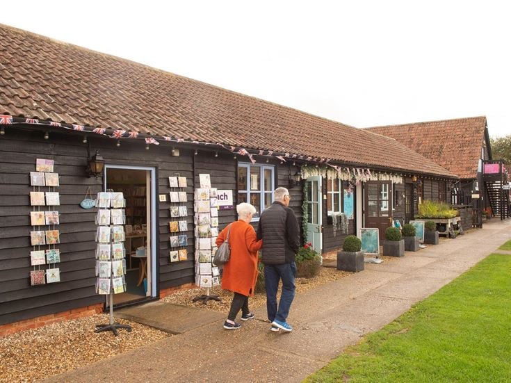 Two seniors walk outside various shops at Holme Grange Craft Centre in Wokingham.