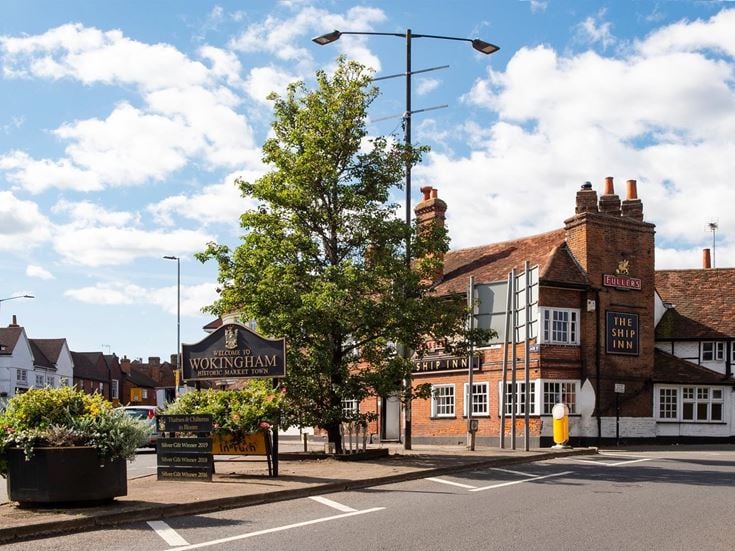 Street entrance of Wokingham with a welcome sign and local pub.