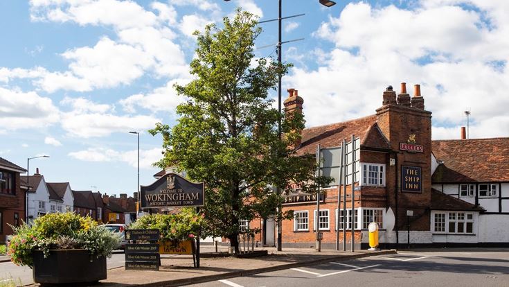 Street entrance of Wokingham with a welcome sign and local pub.