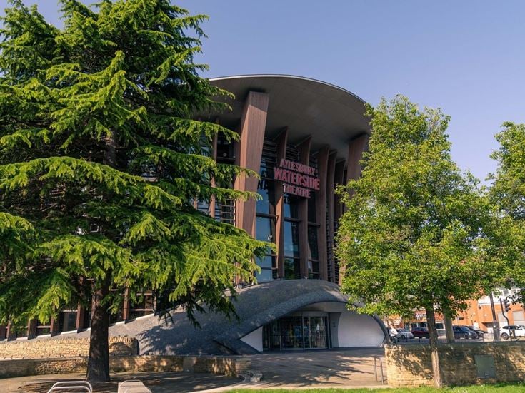 The outside of Aylesbury Waterside Theatre, surrounded by green trees.