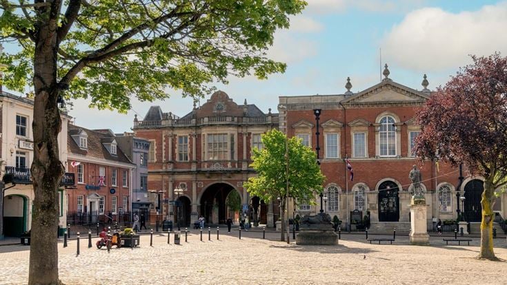A courtyard in Aylesbury town centre, ringed with red brick buildings on a sunny day.