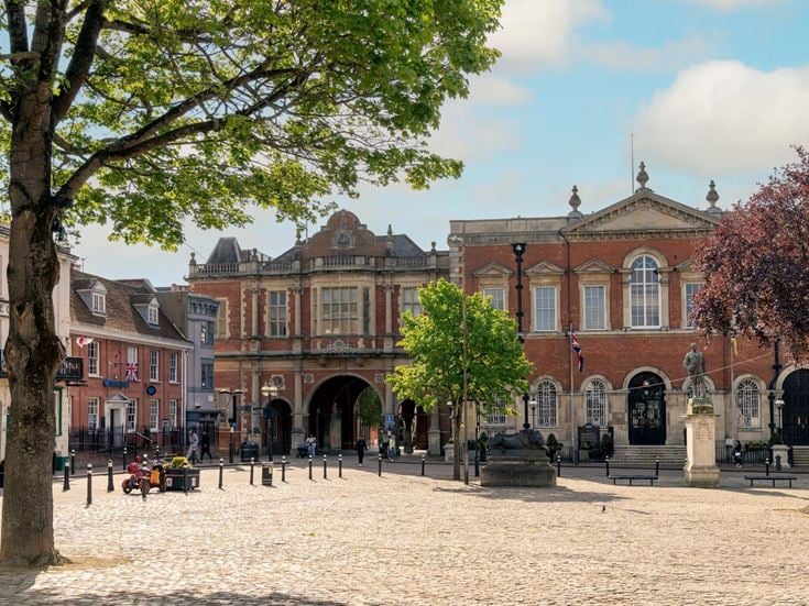 A courtyard in Aylesbury town centre, ringed with red brick buildings on a sunny day.