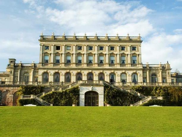 Cliveden House on a cloudy day, with a large lawn in the front.