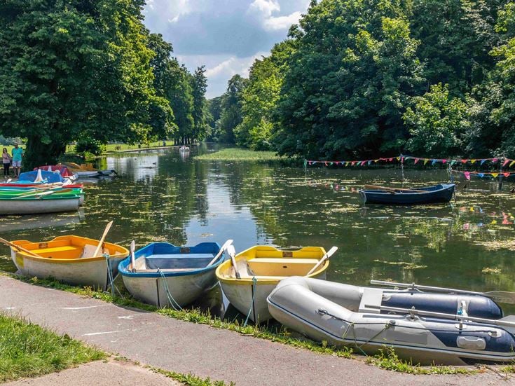 a group of boats sit on the side of a river