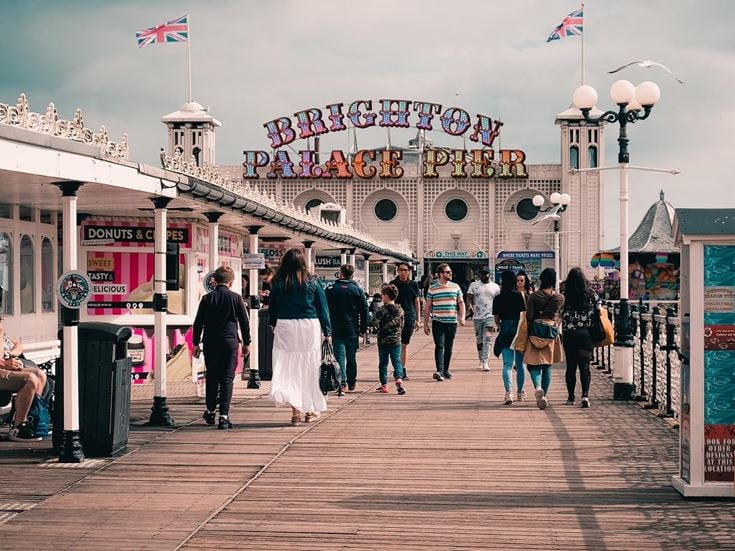 Visitors walk along the entrance to Brighton Palace Pier.