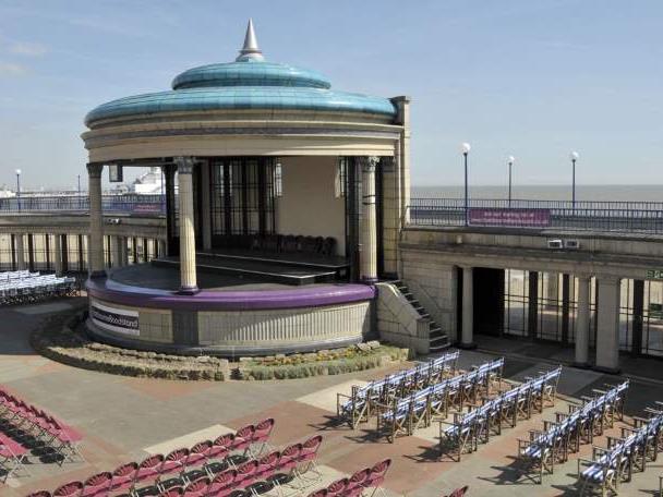 Chairs surround the Eastbourne Bandstand, a seafront venue in Eastbourne.