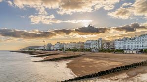 A beach in Eastbourne at sunset with buildings along the seafront.