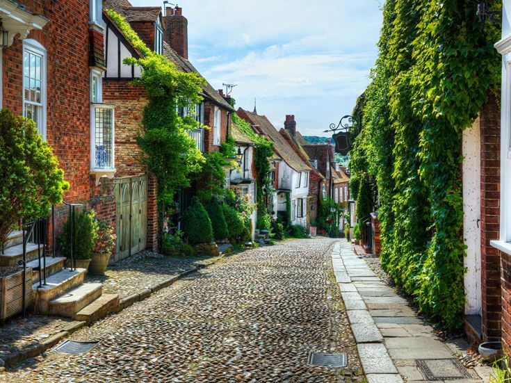 A cobbled street in Rye, East Sussex, with ivy growing over the buildings.