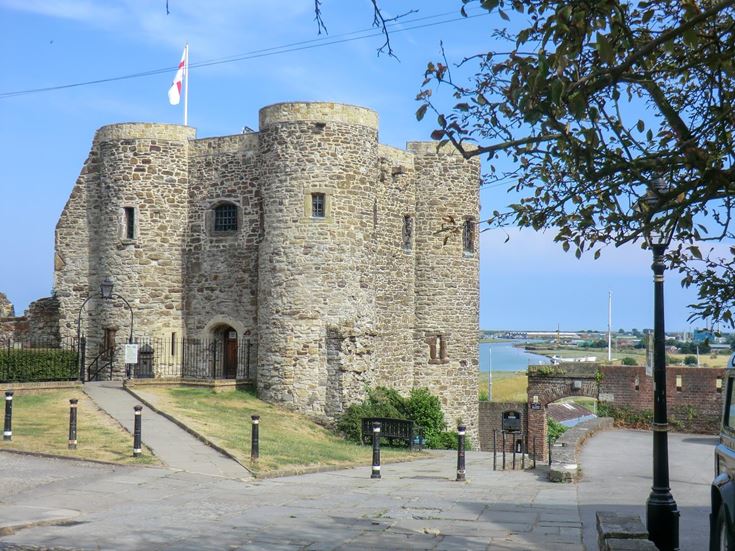 Ypres Tower in Rye, East Sussex, on a sunny day surrounded by pathways and greenery.